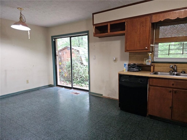 kitchen featuring a sink, dishwasher, a wealth of natural light, and light countertops