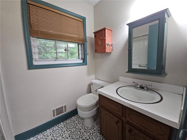 bathroom featuring vanity, baseboards, visible vents, and toilet