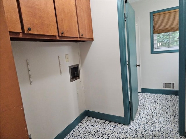 washroom featuring washer hookup, baseboards, cabinet space, and visible vents