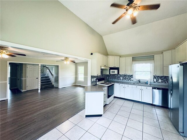 238 Marks Rd, Mansfield, GA 30055 - kitchen featuring appliances with stainless steel finishes, a ceiling fan, open floor plan, high vaulted ceiling, and decorative backsplash