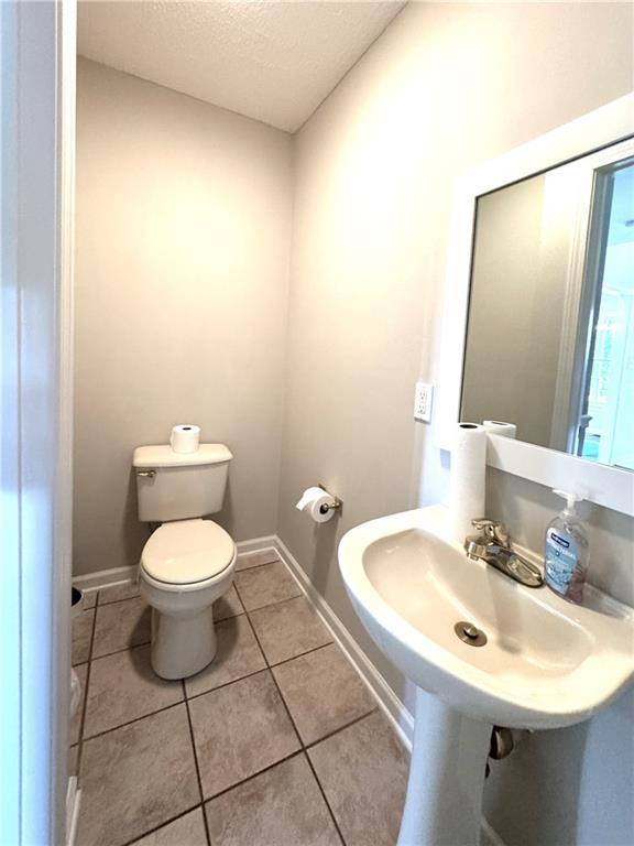 238 Marks Rd, Mansfield, GA 30055 - half bath with a textured ceiling and tile patterned floors