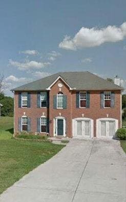 9066 Bob Jackson Dr, Jonesboro, GA 30238 - colonial house with driveway, a front yard, and a chimney