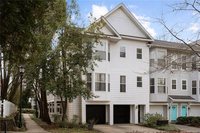 townhome / multi-family property featuring concrete driveway and a garage