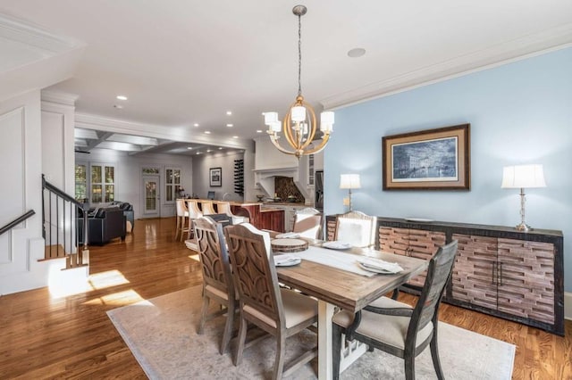 dining room with a chandelier, crown molding, wood-type flooring, and beamed ceiling