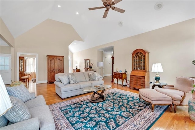 living room with baseboards, ceiling fan, recessed lighting, light wood-style flooring, and high vaulted ceiling