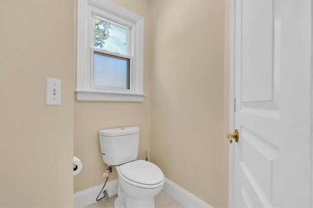 bathroom featuring tile patterned flooring, toilet, and baseboards