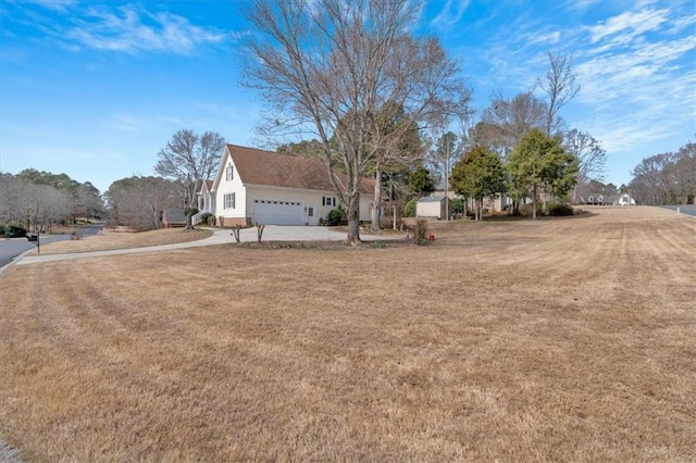 view of yard featuring concrete driveway and an attached garage