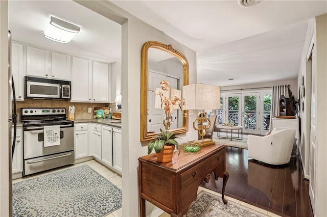 3650 Ashford Dunwoody Rd NE Unit 1024, Atlanta, GA 30319 - kitchen featuring appliances with stainless steel finishes, white cabinetry, and decorative backsplash