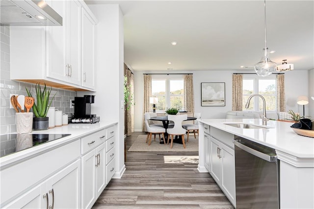 kitchen featuring dishwasher, a sink, plenty of natural light, light wood-style flooring, and recessed lighting