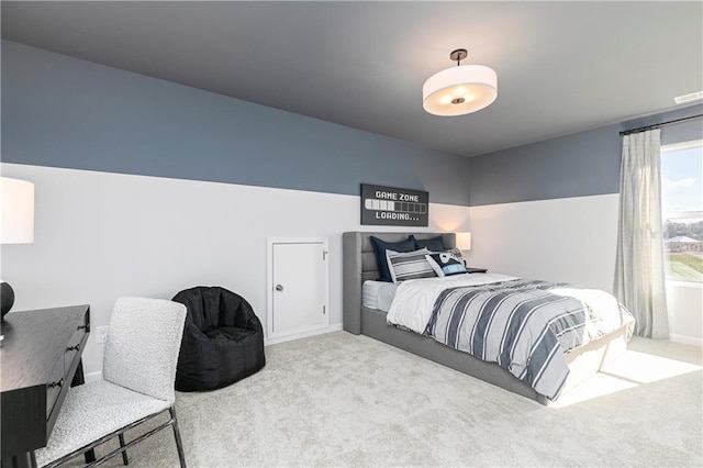 carpeted bedroom featuring baseboards and a desk