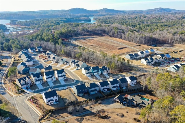 aerial view of property and surrounding area featuring a heavily wooded area and mountains