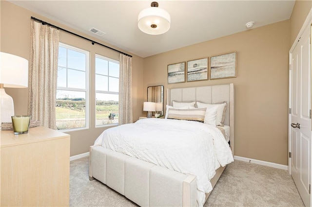 bedroom with light carpet and baseboards