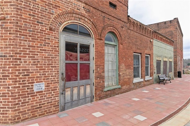 doorway to property with brick siding