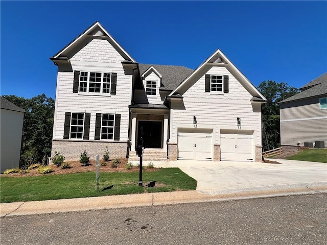 view of front of property with a front yard, brick siding, driveway, and an attached garage