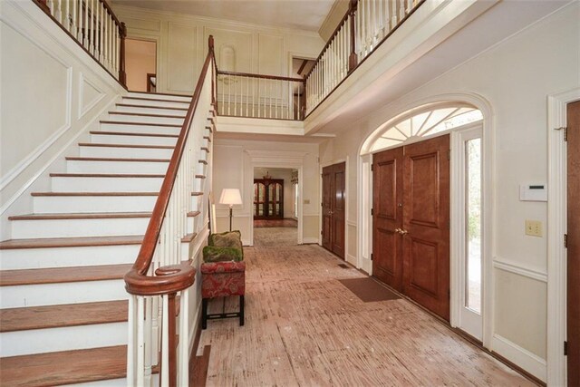 living room featuring hardwood / wood-style floors, crown molding, and a brick fireplace