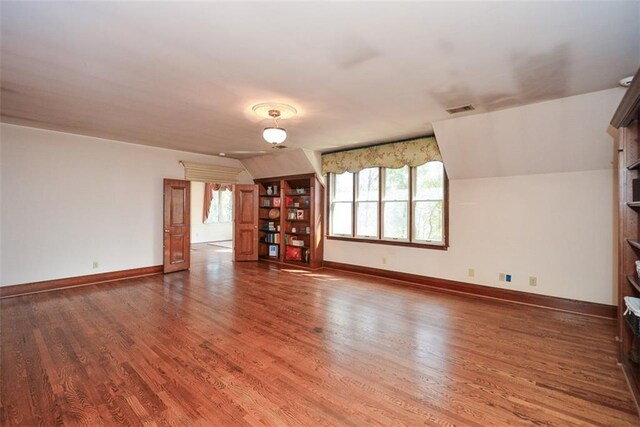 walk in closet featuring wood-type flooring and vaulted ceiling