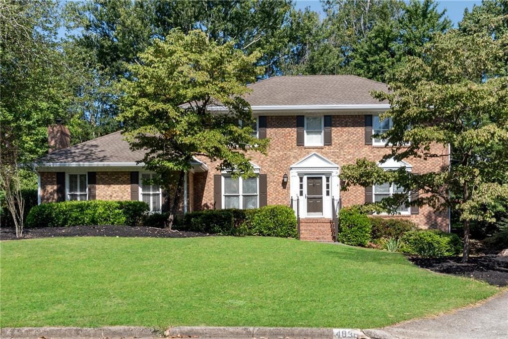 colonial home with a front lawn