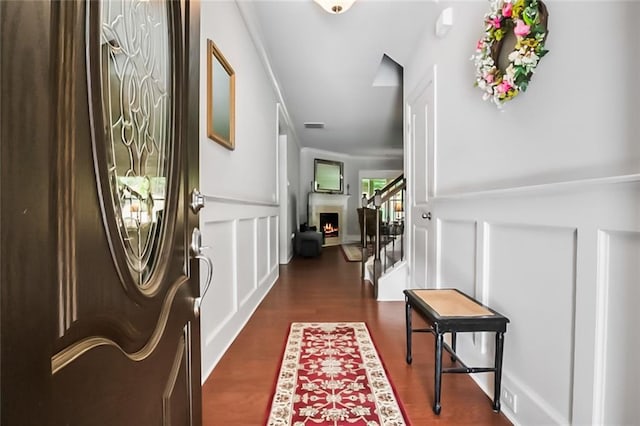 4547 Big Rock Ridge Trl SW, Gainesville, GA 30504 - entryway with stairway, a decorative wall, wood finished floors, a lit fireplace, and crown molding