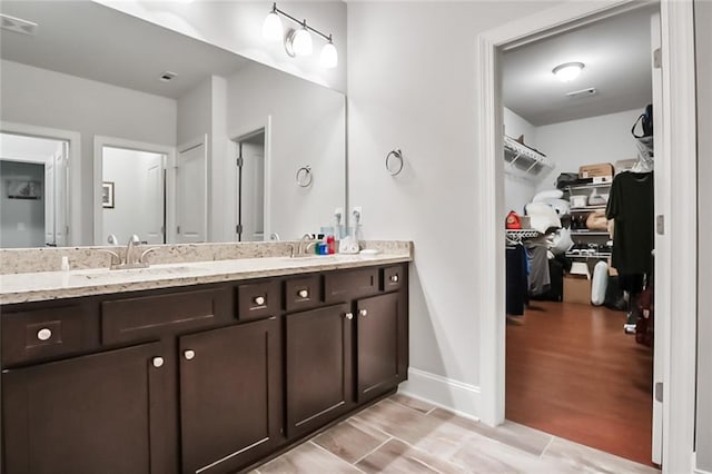 4547 Big Rock Ridge Trl SW, Gainesville, GA 30504 - full bathroom with double vanity, a spacious closet, and wood finished floors