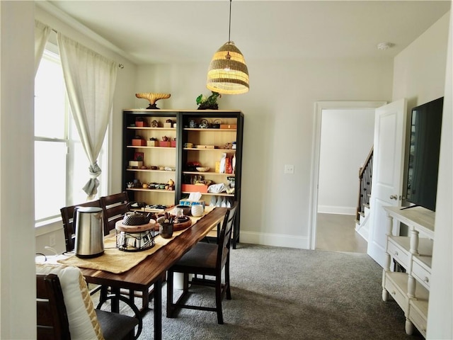 dining room with carpet floors, baseboards, stairway, and a healthy amount of sunlight