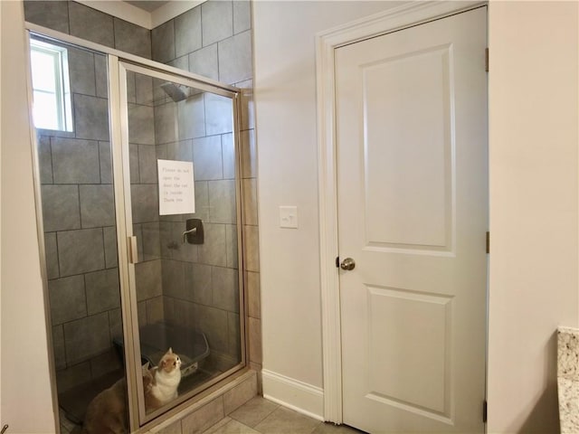 full bath with baseboards and a shower stall