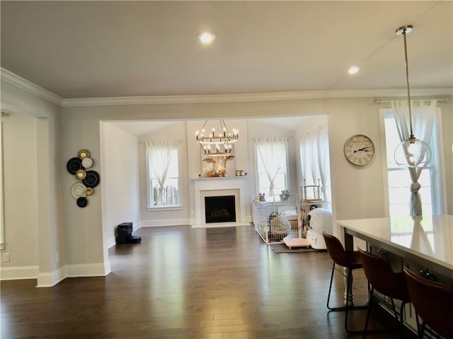 living room featuring crown molding, baseboards, a notable chandelier, and dark wood finished floors
