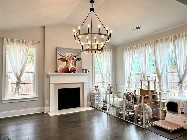 interior space with visible vents, an inviting chandelier, wood finished floors, and lofted ceiling