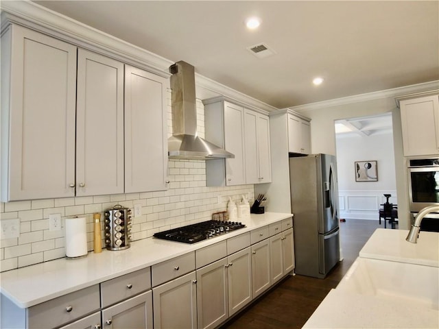 kitchen with visible vents, gray cabinetry, wall chimney exhaust hood, and stainless steel appliances