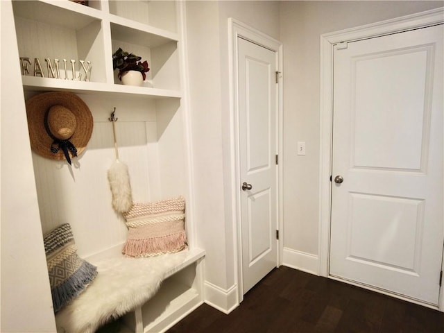mudroom featuring dark wood-type flooring and baseboards
