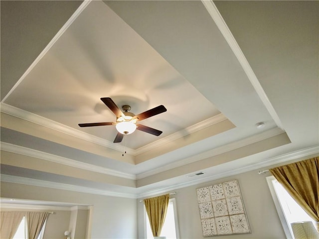 interior details with ceiling fan, visible vents, crown molding, and a raised ceiling