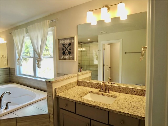 full bathroom with visible vents, a shower stall, vanity, and a garden tub