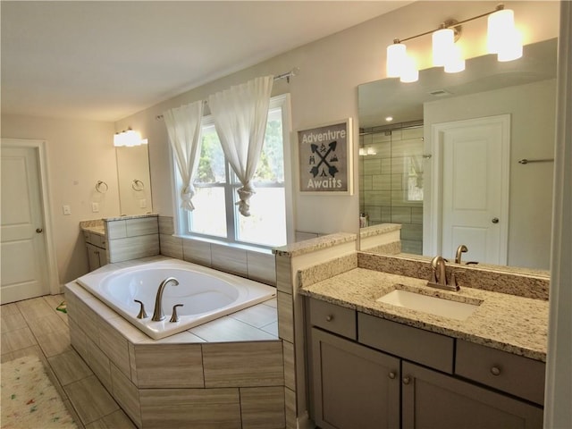 full bath featuring a stall shower, a garden tub, and vanity
