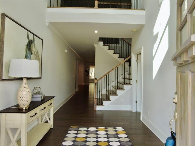 entrance foyer featuring a high ceiling, wood finished floors, and stairs