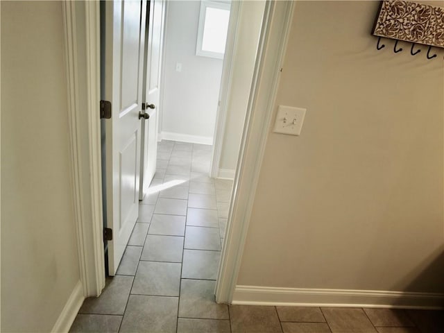 hall with tile patterned floors and baseboards