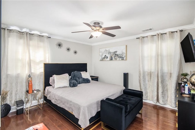 bedroom featuring visible vents, ornamental molding, and wood finished floors