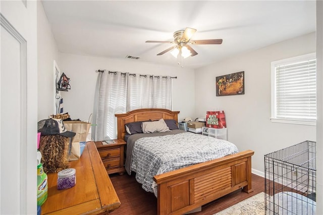 bedroom with ceiling fan, visible vents, baseboards, and dark wood-style floors