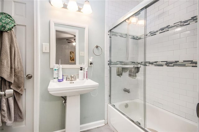 bathroom with baseboards and shower / bath combination with glass door