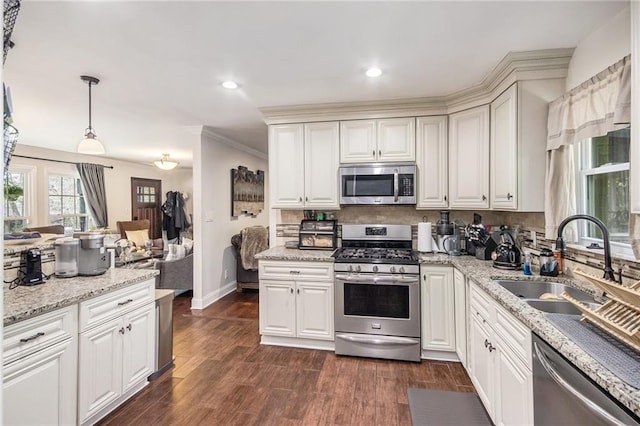 kitchen featuring tasteful backsplash, appliances with stainless steel finishes, dark wood-type flooring, and a sink