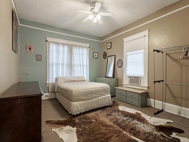 carpeted bedroom with a textured ceiling, cooling unit, and ceiling fan