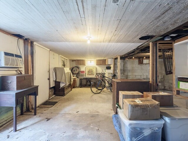 basement featuring wood ceiling and a wall unit AC