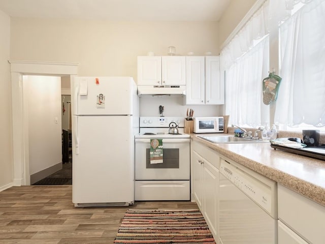 kitchen featuring white cabinetry, light wood-type flooring, sink, and white appliances