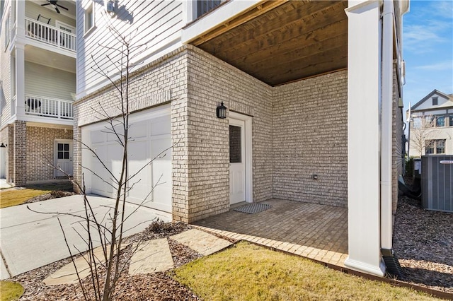 doorway to property with a garage and central AC unit