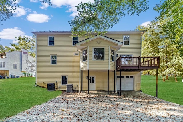 rear view of property featuring a wooden deck, a garage, a yard, and central air condition unit