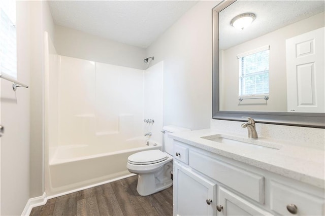 full bathroom with toilet, vanity, shower / bathing tub combination, wood finished floors, and a textured ceiling