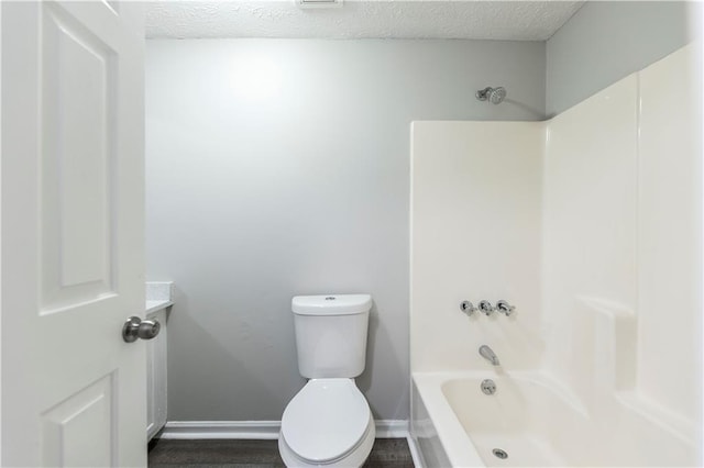 full bathroom featuring shower / bathing tub combination, toilet, baseboards, and a textured ceiling