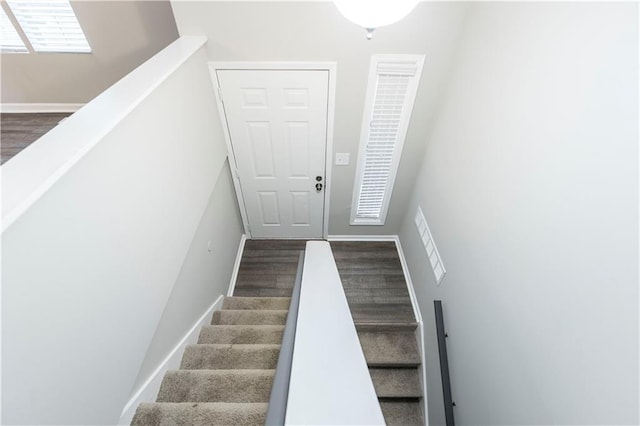 stairway with wood finished floors and baseboards