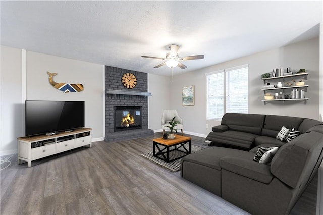 living room featuring a fireplace, wood finished floors, baseboards, and a ceiling fan