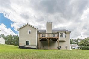 rear view of property with a yard and a deck