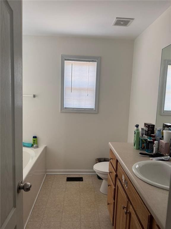 bathroom featuring a tub to relax in, vanity, and toilet