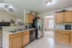 kitchen with lofted ceiling, black dishwasher, sink, stainless steel fridge, and stove